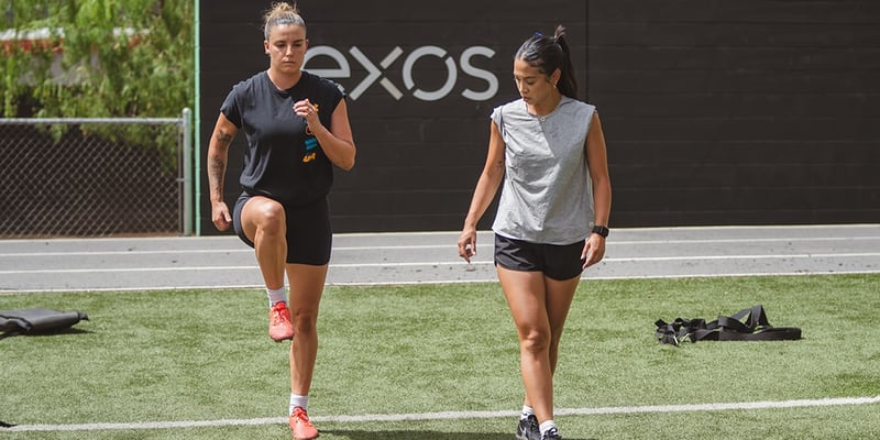 Coach Pauline training an athlete at an Exos facility.